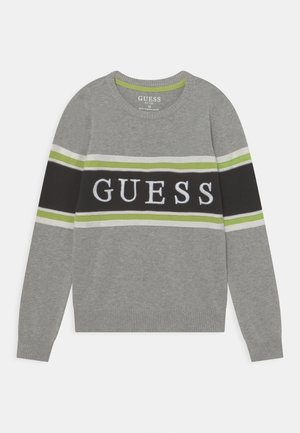 Grå tröja med långa ärmar och gröna samt svarta ränder. "GUESS"-logotyp i vitt över mitten. Ribbad muddar och nederkant.