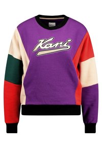 Sudadera de gran tamaño y colorida, hecha de una mezcla de algodón. Presenta paneles en púrpura, rojo, verde y beige con el logotipo "Kani" en cursiva blanca en la parte frontal.