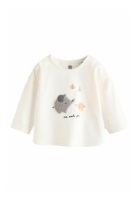 Camisa blanca de manga larga hecha de algodón, con un bordado texturizado en gris de un elefante y animales más pequeños acompañado del texto "yo y tú".