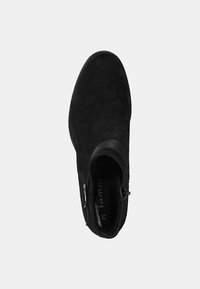 Czarne zamszowe botki za kostkę o gładkiej fakturze, z boku zapinane na zamek błyskawiczny oraz zaokrąglonym czubkiem. Charakteryzują się minimalnym przeszyciem i subtelnym szwem wzdłuż górnej części.