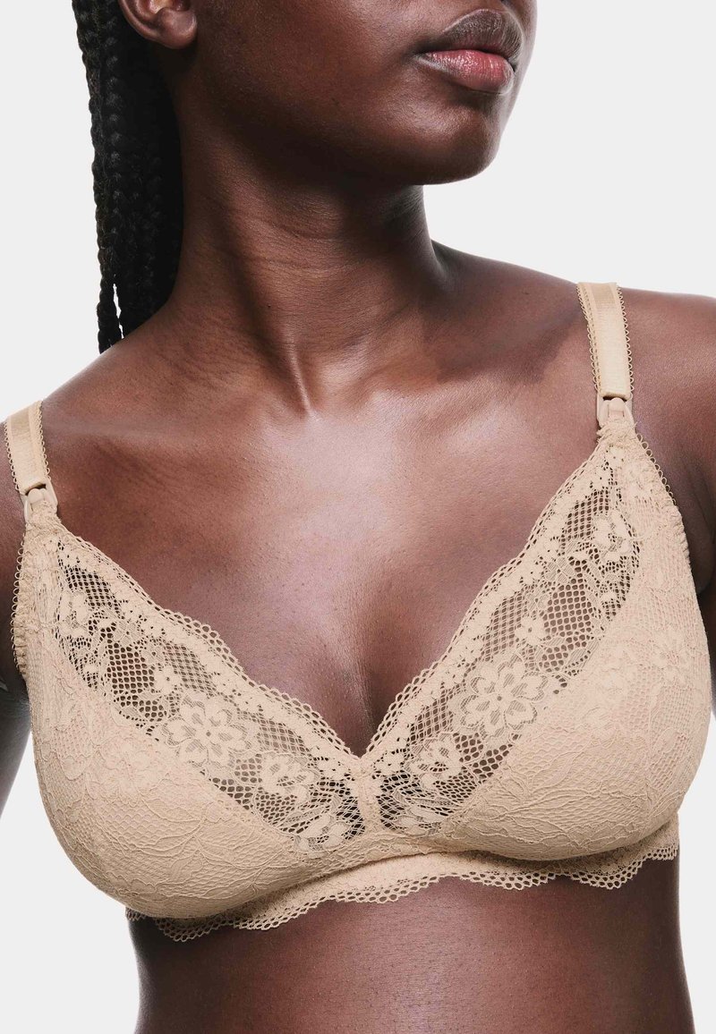 Sujetar beige de encaje con diseño de escote en V, patrones florales y tirantes ajustables. Textura suave con bordes delicados en forma de ondas.