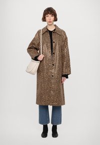 Leopard print, knee-length, glossy coat with large collar and buttons, paired with black top, cropped blue jeans, and black shoes.