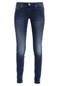 Jeans ajustados en denim azul oscuro con un ligero desgaste. Presentan un diseño clásico de cinco bolsillos, botón de metal y acentos de costura en contraste.
