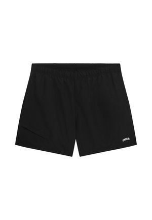 Schwarze Sportshorts mit elastischem Bund und kleinem weißem "UNFAIR"-Logo am unteren rechten Bein.