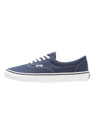 Niskie trampki Vans w kolorze granatowym z białymi sznurowadłami, białą gumową podeszwą i metką z logo Vans po boku.