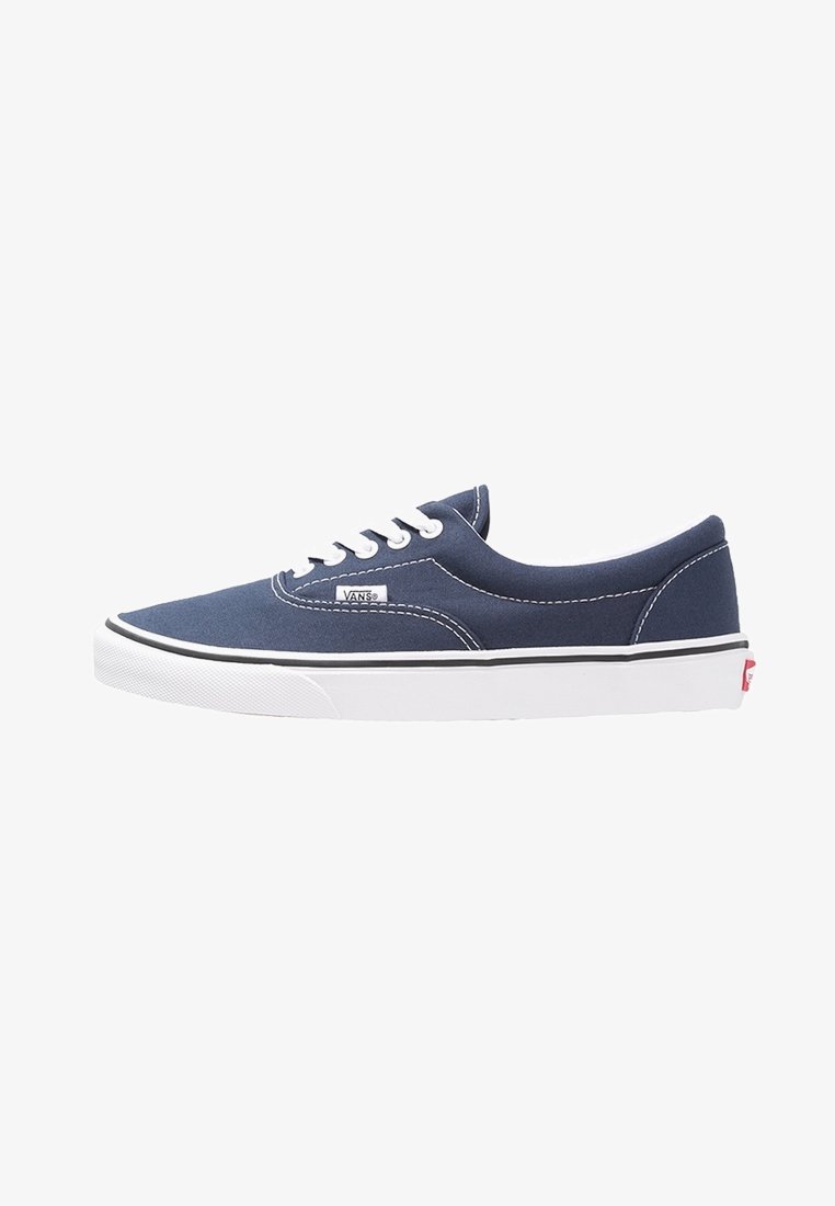 Baskets basses Vans bleu marine avec lacets blancs, semelle en caoutchouc blanche et étiquette logo Vans sur le côté.