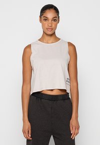 Jasnoszara krótka bluzka na ramiączkach z okrągłym dekoltem, bez rękawów, z czarnym napisem na dole. Wykonana z miękkiego materiału, o luźnym kroju.