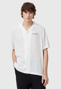 Witte short-sleeve shirt met een knoopsluiting, lichtgewicht stof en een klein logo in donkerrood op de linkerkant van de borst.