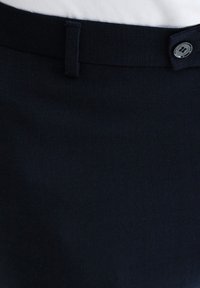 Ciemnoniebieska spódnica z fakturowanej tkaniny. Posiada widoczny guzik w talii oraz pętelkę, co tworzy dopasowaną sylwetkę. Gładkie wykończenie.