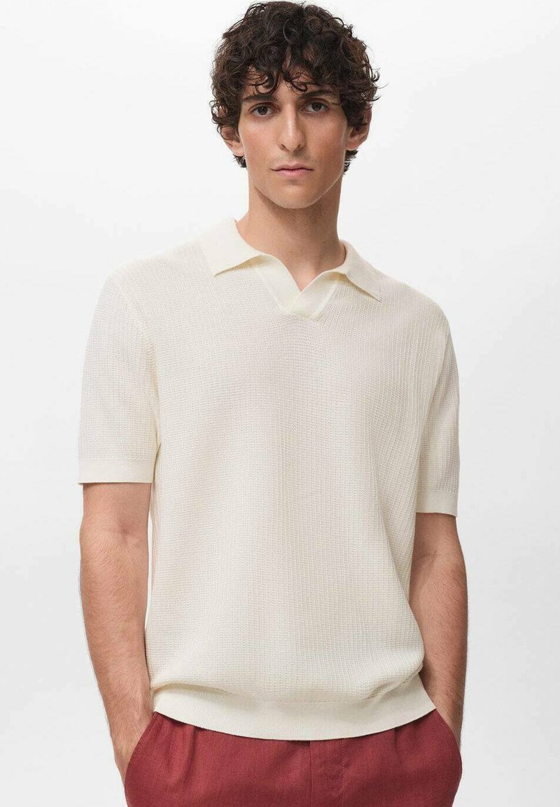 Short-sleeve pullover in textured cream fabric, featuring a V-shaped collar and fine knit design. Paired with dark red trousers.