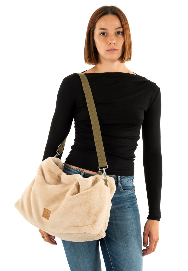 Borsa in pile beige dalla texture morbida, design morbido e tracolla regolabile verde oliva. Presenta una piccola toppa con logo sul davanti.