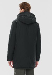 Czarna, kapturowa kurtka o gładkiej fakturze, z prostym krojem, bocznymi kieszeniami i średniej długości designem. Widok z tyłu.
