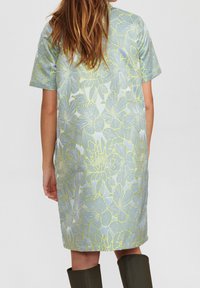 Kortärmad klänning i lätt material med ett blått och grönt blommönster. Har en lös passform och når till mitten av låret.