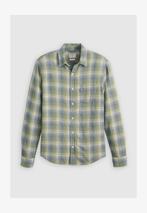 Camicia di flanella a quadri verdi e blu con colletto a bottoni, tasca sul petto e bottoni bianchi. Tessuto testurizzato con una vestibilità rilassata.