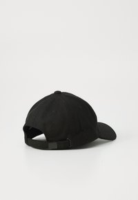 Gorra de algodón negra con una ligera curvatura en la visera, correa ajustable en la parte posterior y una tela texturizada. Los detalles de las costuras son mínimos.