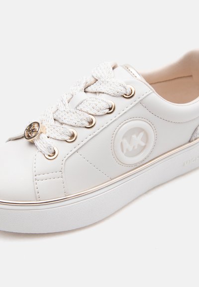 Λευκό δερμάτινο αθλητικό παπούτσι με παχιά σόλα, υφασμένα λευκά κορδόνια με χρυσές λεπτομέρειες και ανάγλυφο κυκλικό λογότυπο στη πλευρά.