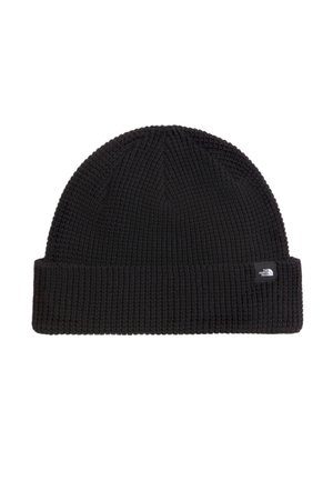 Bonnet noir en tricot avec bord replié et petite étiquette de marque rectangulaire noire et blanche sur le revers.