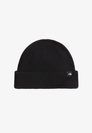 Czarna dzianinowa czapka typu beanie z podwiniętym brzegiem i małą prostokątną czarno-białą metką marki na mankiecie.