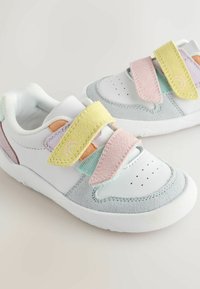 White and grey sneakers with pastel Velcro straps in yellow, pink, mint, and orange. Features perforated toe and textured accents.