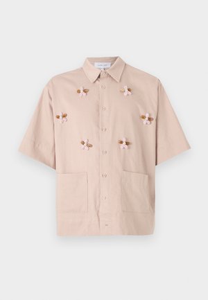 Camisa de manga curta, com colarinho, em algodão bege claro, com dois bolsos frontais, apresentando bordados florais em rosa e castanho na frente.