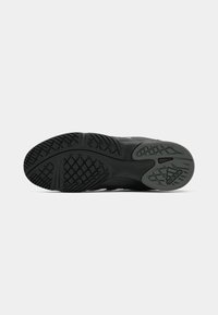 Suola di scarpa sportiva nera con gomma testurizzata, caratterizzata da un motivo di battistrada distintivo e dettagli del logo. Progettata per aderenza e durata.