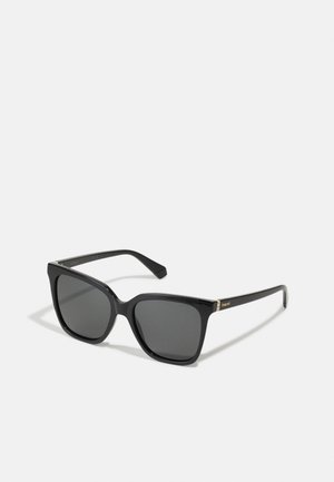 Lunettes de soleil rectangulaires noires avec des verres foncés, cadre en plastique brillant et subtiles accents dorés sur les charnières. Design surdimensionné classique.