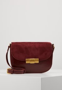 Borsa in pelle bordeaux con pattina in suede, chiusura in metallo dorato e tracolla intrecciata. Presenta superfici lisce e testurizzate.