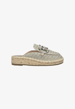 Espadrille beige tissée à enfiler avec une surface texturée, une large sangle et une boucle décorative en argent. Semelle extérieure en fibres naturelles.