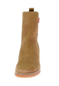 Botín de ante marrón con punta redonda, tira para tirar en la parte trasera y suela de goma. Textura suave, diseño minimalista, sin patrones visibles.