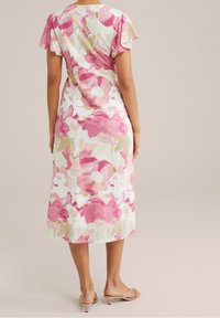 Květinové midi šaty s krátkými flutter rukávy, které zdobí velké růžové a béžové květiny na bílém pozadí a mají rovný lem.