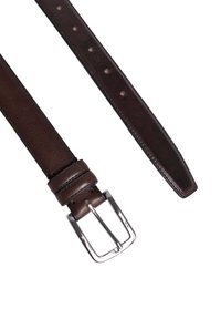 Bruine leren riem met een gladde textuur, zilveren metalen gesp en vijf verstelgaten langs de band voor maatvariabiliteit.