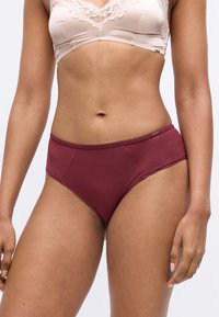 Bordeauxfarbene, hoch geschnittene Slips mit strukturierten Seitenpanelen, ausgestattet mit glattem Stoff und einem weichen Bund für zusätzlichen Komfort.