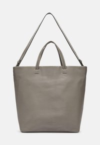 Grijze leren tote bag met dubbele handgrepen en een afneembare schouderriem. Zachte textuur met subtiele stiksels en logo-detail aan de voorkant.