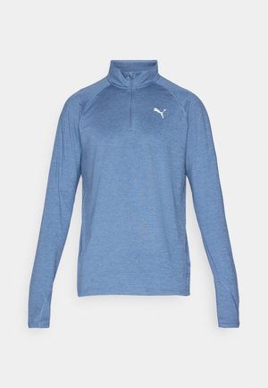 Long-sleeve, light blue pullover shirt with a quarter-zip collar, made from breathable fabric. Features a small white logo on the chest.