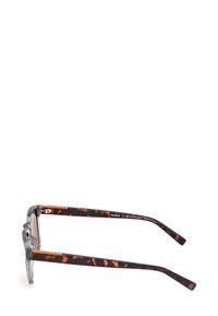 Occhiali da sole tortoiseshell marroni con montatura grigia trasparente, forma leggermente curvata e asticelle dritte con dettagli metallici. Le lenti sono leggermente scure.