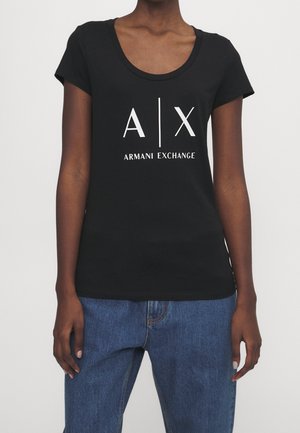 T-shirt en coton noir avec un col rond dégagé et des manches courtes. Présente un logo graphique blanc "A|X ARMANI EXCHANGE" centré sur le devant.