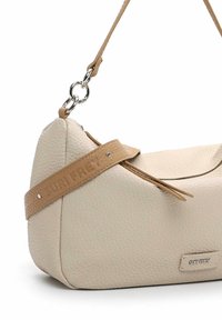 Sac à bandoulière en cuir texturé couleur crème avec une sangle camel, une quincaillerie argentée, et le logo "SURI FREY" embossé et sur une petite plaque métallique.