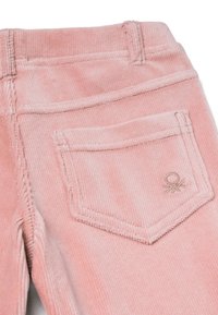 Růžové kordové kalhoty s zadní kapsou s vyšívaným detailem, texturovanou látkou a viditelným šitím podél švů.