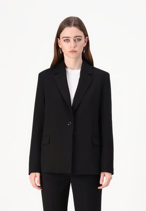 Svart skreddersydd blazer med en enkelt knapplukking, notched lapels og sidelommer. Glatt stoff, strukturert passform og minimalistisk design.