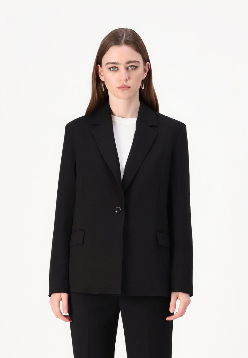 Čierny na mieru šitý blazer s jedným gombíkom, klopovými goliermi a bočnými vreckami. Hladká tkanina, štruktúrovaný strih a minimalistický dizajn.