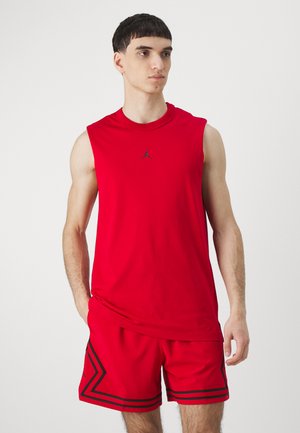 Rød ærmeløs skjorte med sort Jordan-logo, parret med røde shorts med sorte striber og vinklede mønstre. Glat stof, atletisk pasform.