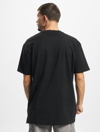 T-shirt en coton noir à coupe décontractée, à manches courtes et col rond. Sans logos ni motifs visibles. Texture lisse et design sobre.