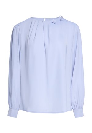 Blouse bleu clair à manches longues, avec des plis près de l'encolure, deux boutons décoratifs sur le col et des poignets amples.