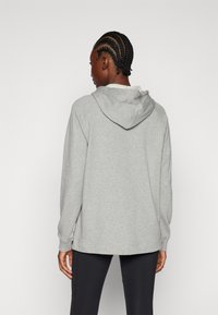 Grijze hoodie met lange mouwen, een kangoeroe-pocket en een verstelbare trekkoordkap. Zacht materiaal met een losse pasvorm en geribde manchetten.