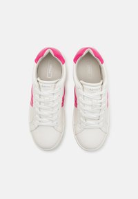 White sneakers with pink accents, lace-up design, smooth texture, rounded toe, and logo detail on the tongue.