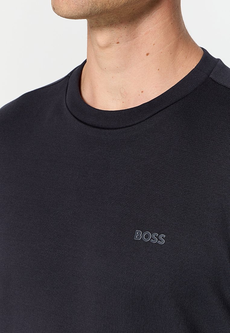 T-shirt à col rond bleu foncé en tissu coton lisse, avec un petit logo "BOSS" ton sur ton sur la poitrine, au design près du corps.