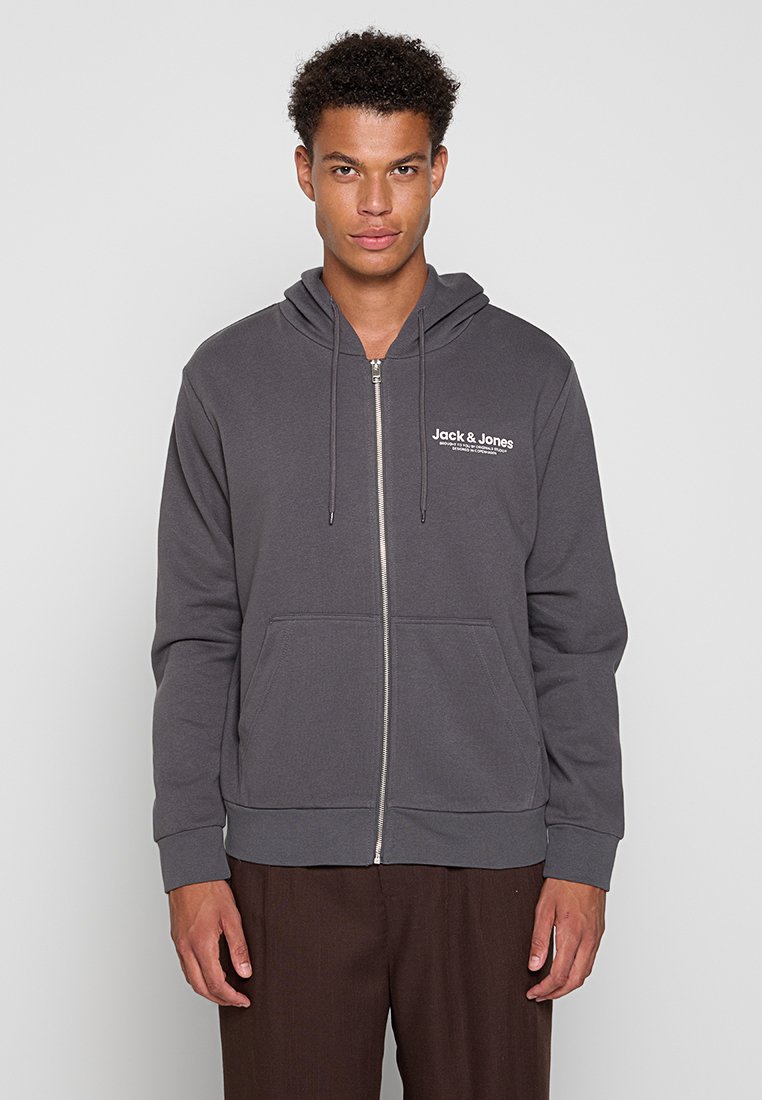 Czarnoszary hoodie na zamek wykonany z miękkiego materiału. Posiada kieszeń kangurką, regulowany kaptur ze sznurkiem oraz białe logo na klatce piersiowej.