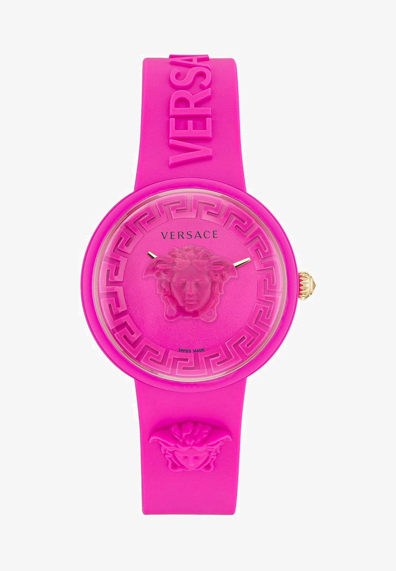 Reloj de silicona rosa con esfera redonda, logo de Medusa en relieve, manecillas doradas y patrón de clave griega en el bisel. Fabricado en Suiza.