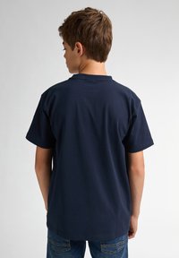 Marineblauwe katoenen T-shirt met korte mouwen en een ronde halslijn, gezien van achteren. Gladde textuur, eenvoudig ontwerp, geen zichtbare patronen of accenten.