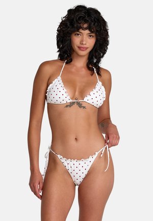 Bikini bianco con pois rossi, caratterizzato da un design arricciato, top triangolare e slip con laccetti laterali regolabili. Texture liscia.